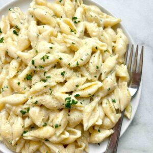 close up of garlic butter pasta shells on plate.
