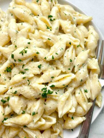 close up of garlic butter pasta shells on plate.
