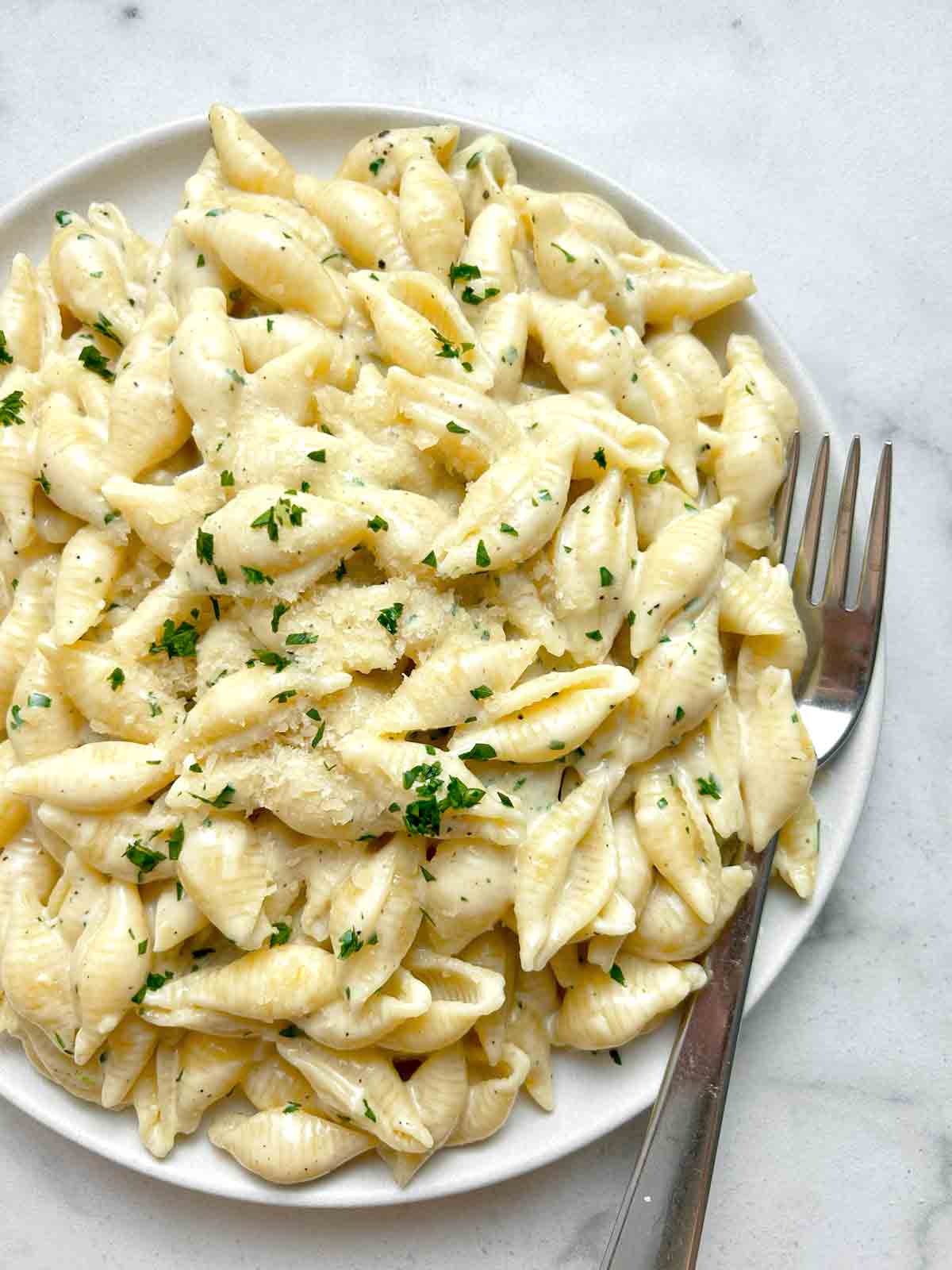 close up of garlic butter pasta shells on plate.