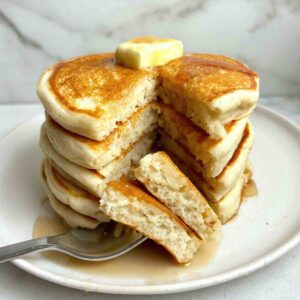 stack of gluten free pancakes with triangular section cut down through the top.