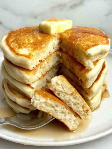 stack of gluten free pancakes with triangular section cut down through the top.