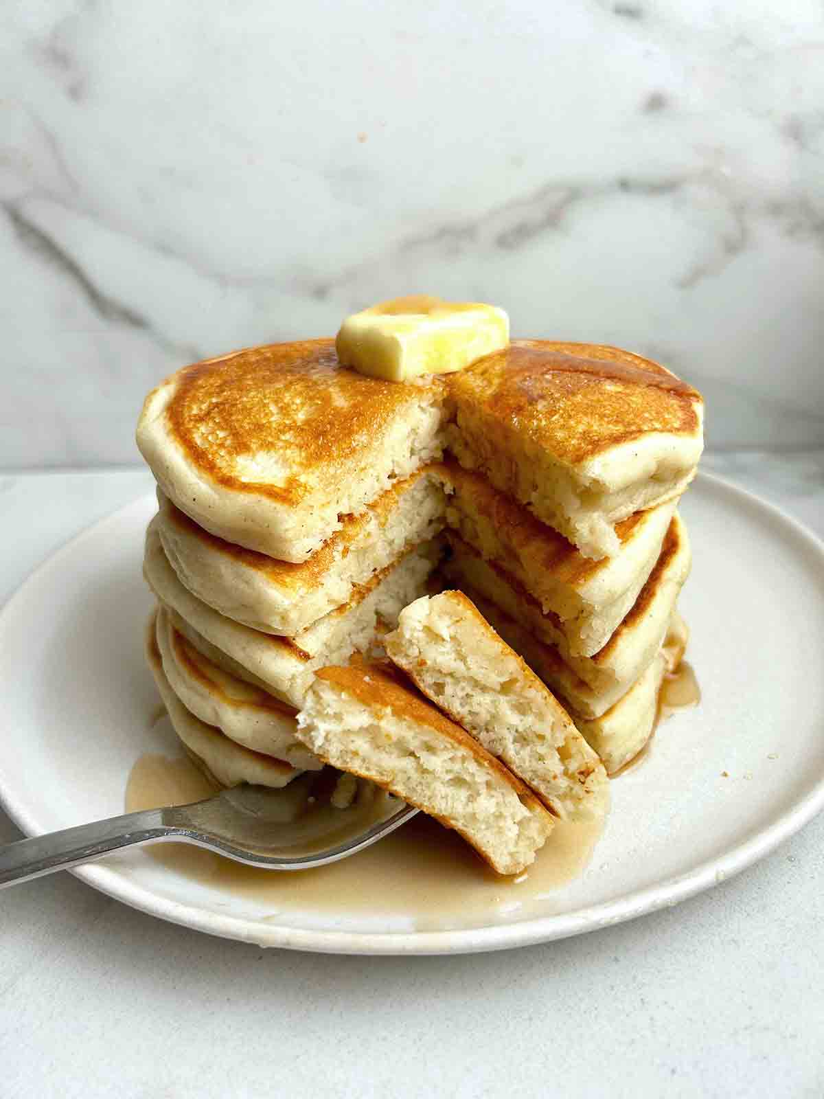 stack of gluten free pancakes with triangular section cut down through the top.