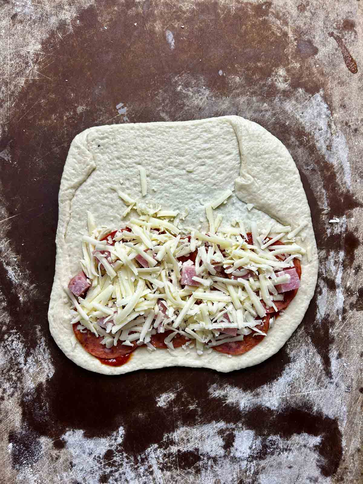 cheese sprinkled on top of ham and pepperoni.