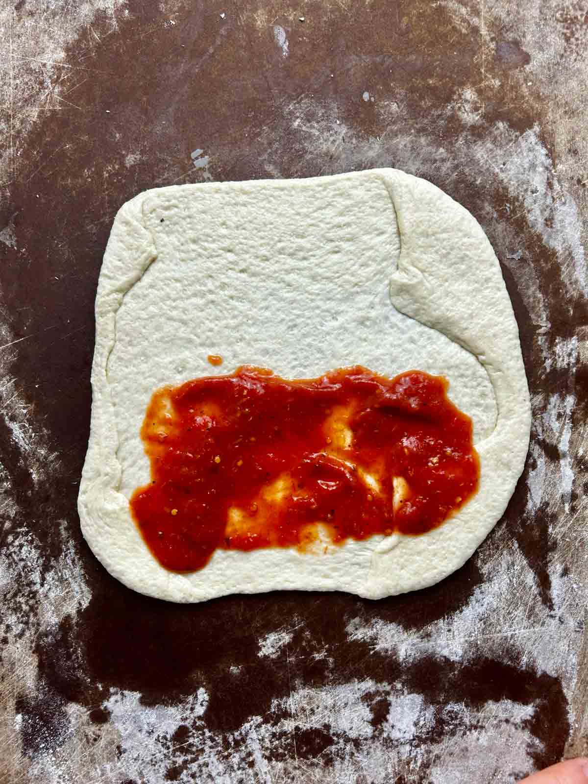 pizza sauce spread on dough.