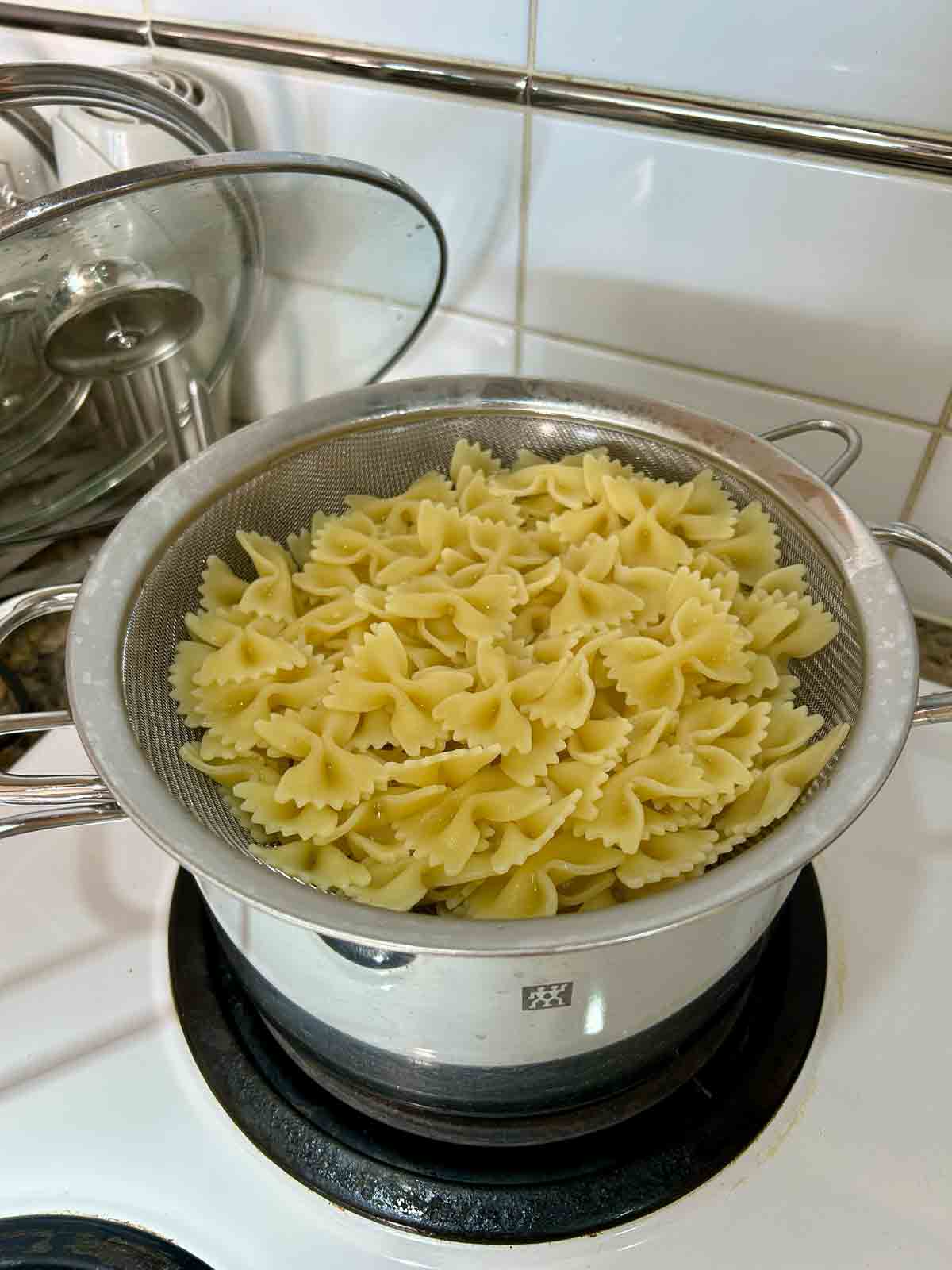 cooked pasta draining in colander.