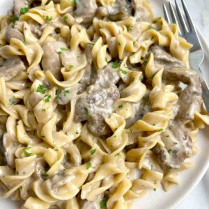close up of beef stroganoff on plate with fork.