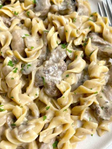 close up of beef stroganoff on plate with fork.