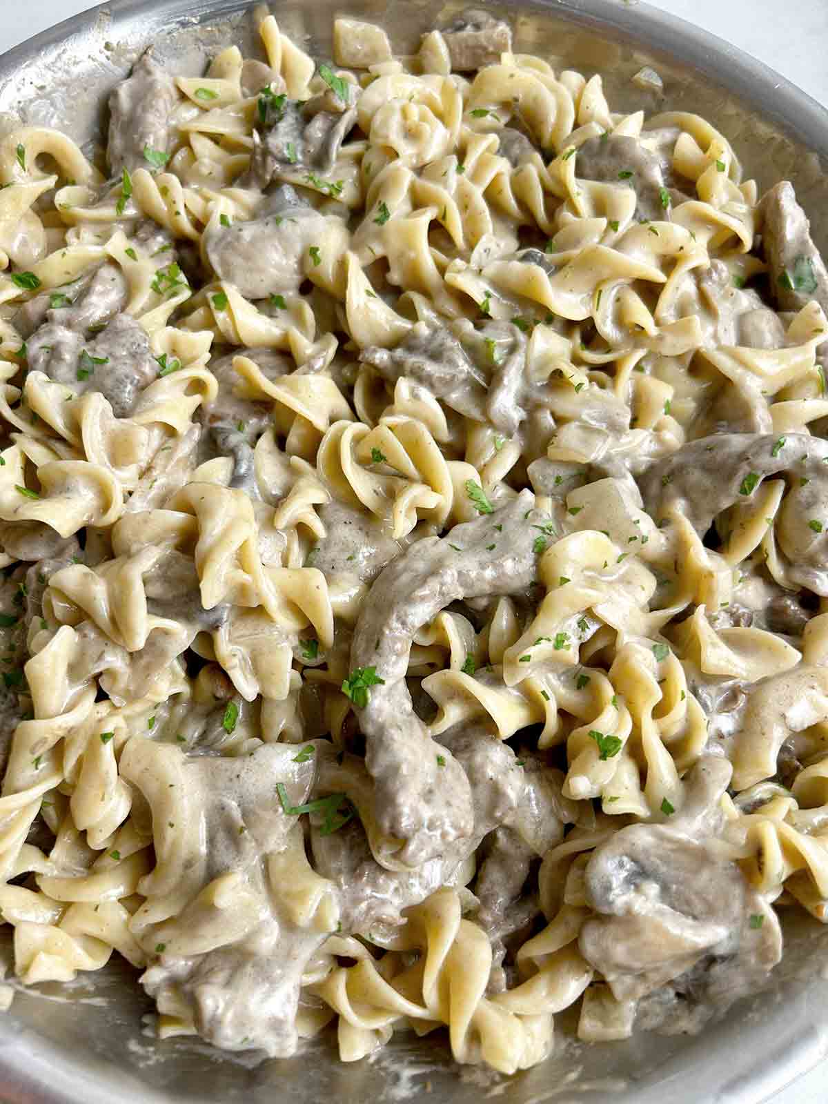 close up of beef stroganoff in large skillet.