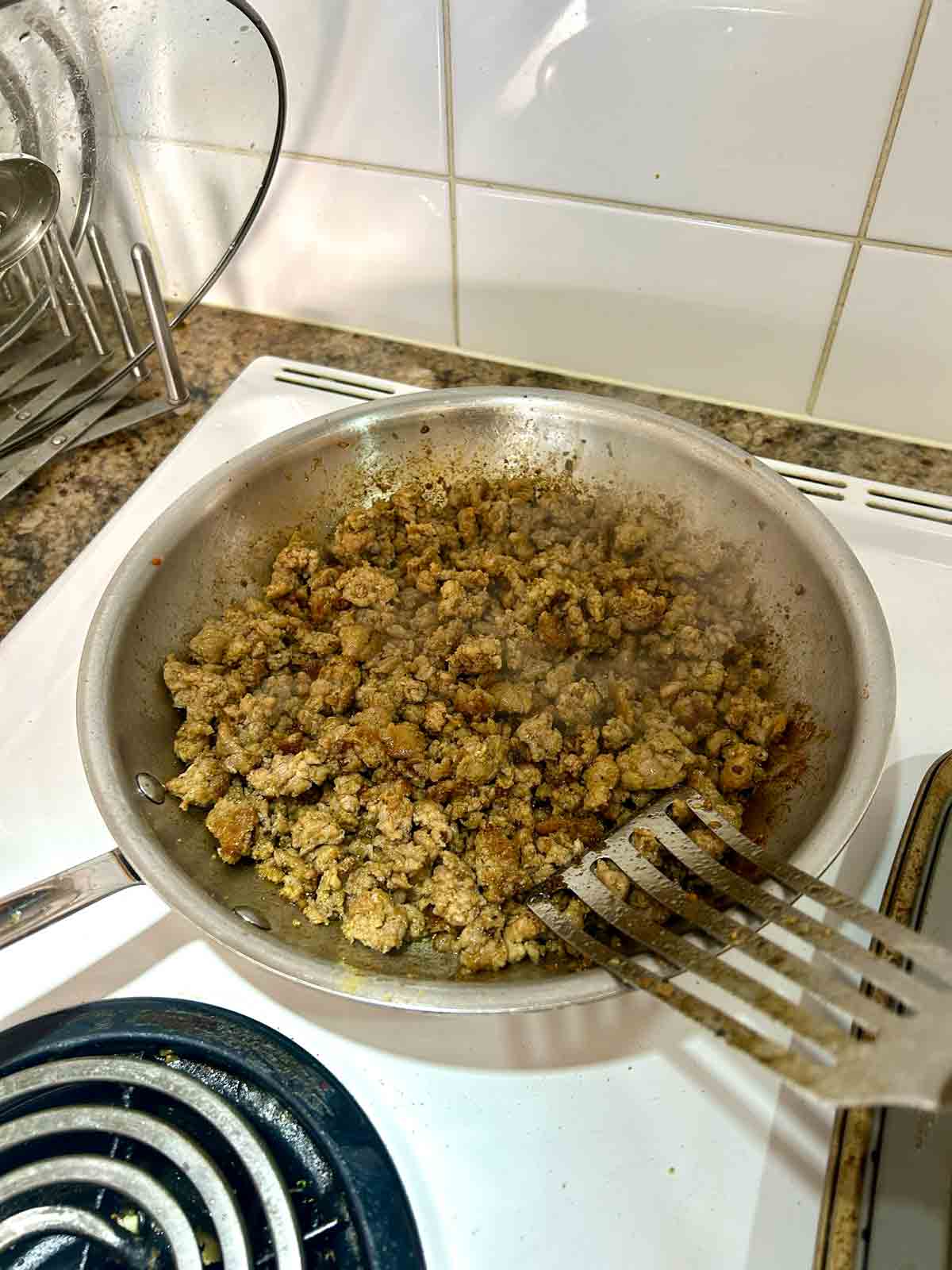 breakfast sausages being cooked in skillet.