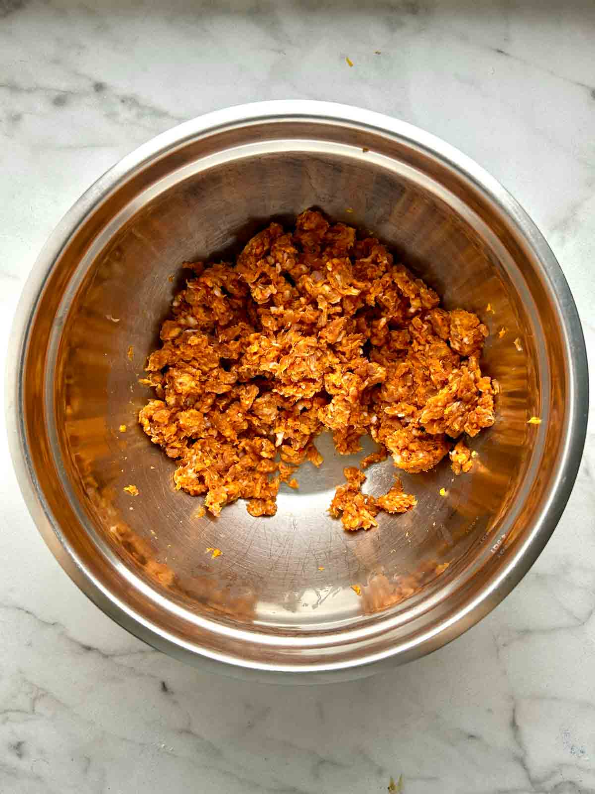 Italian sausages crumbled in bowl.