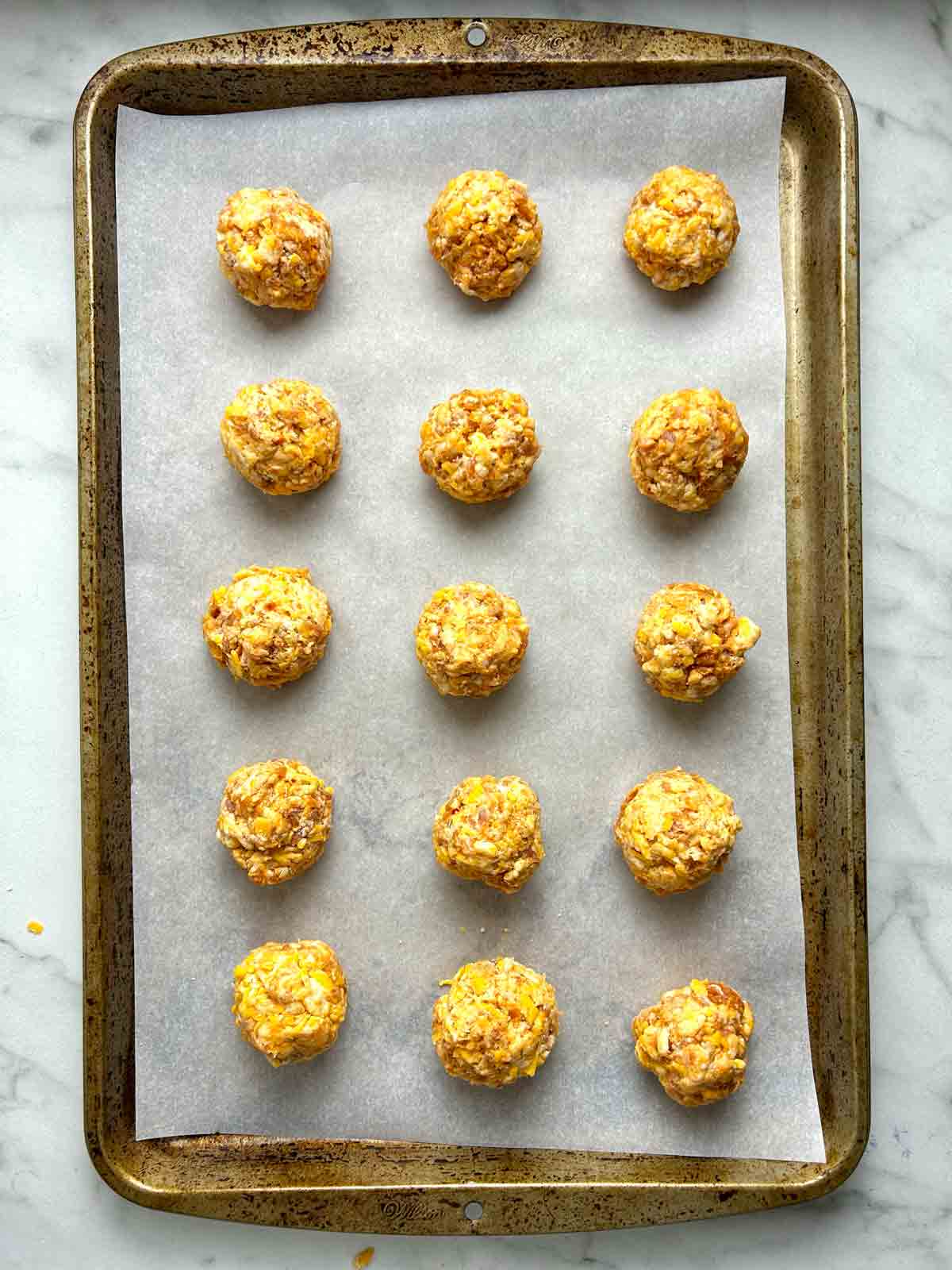dough balls arranged on parchment-lined baking sheet.