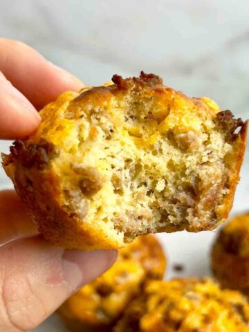 hand holding Bisquick sausage muffin with bite taken out of it.