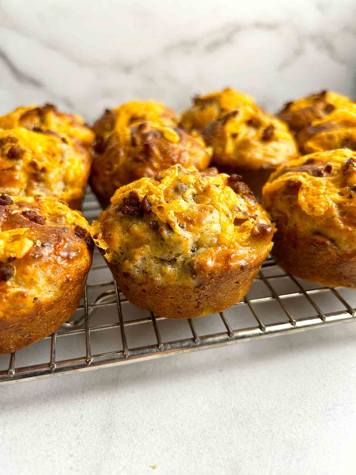 Bisquick sausage muffins sitting on wire rack.