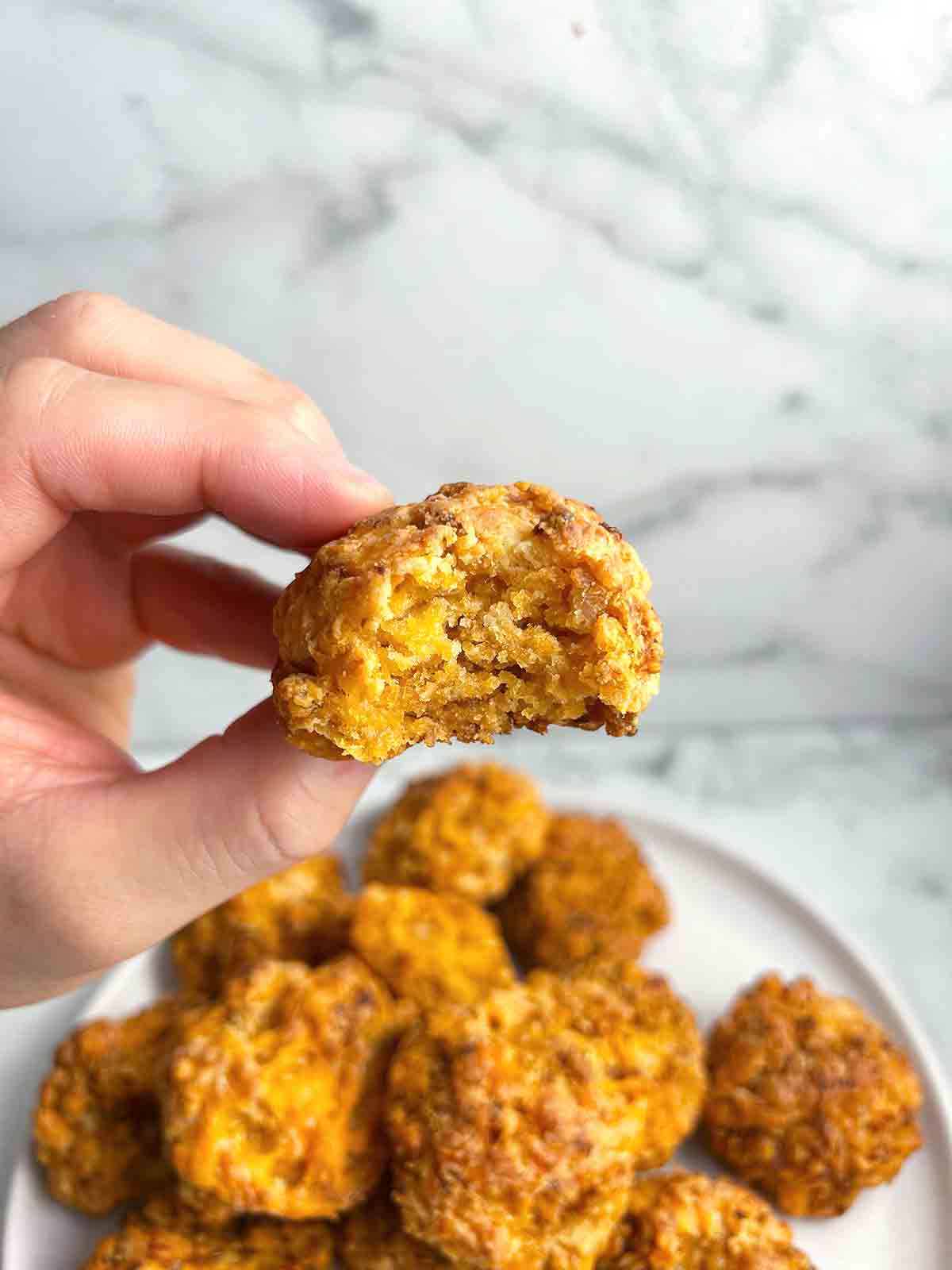 hand holding Bisquick sausage ball.