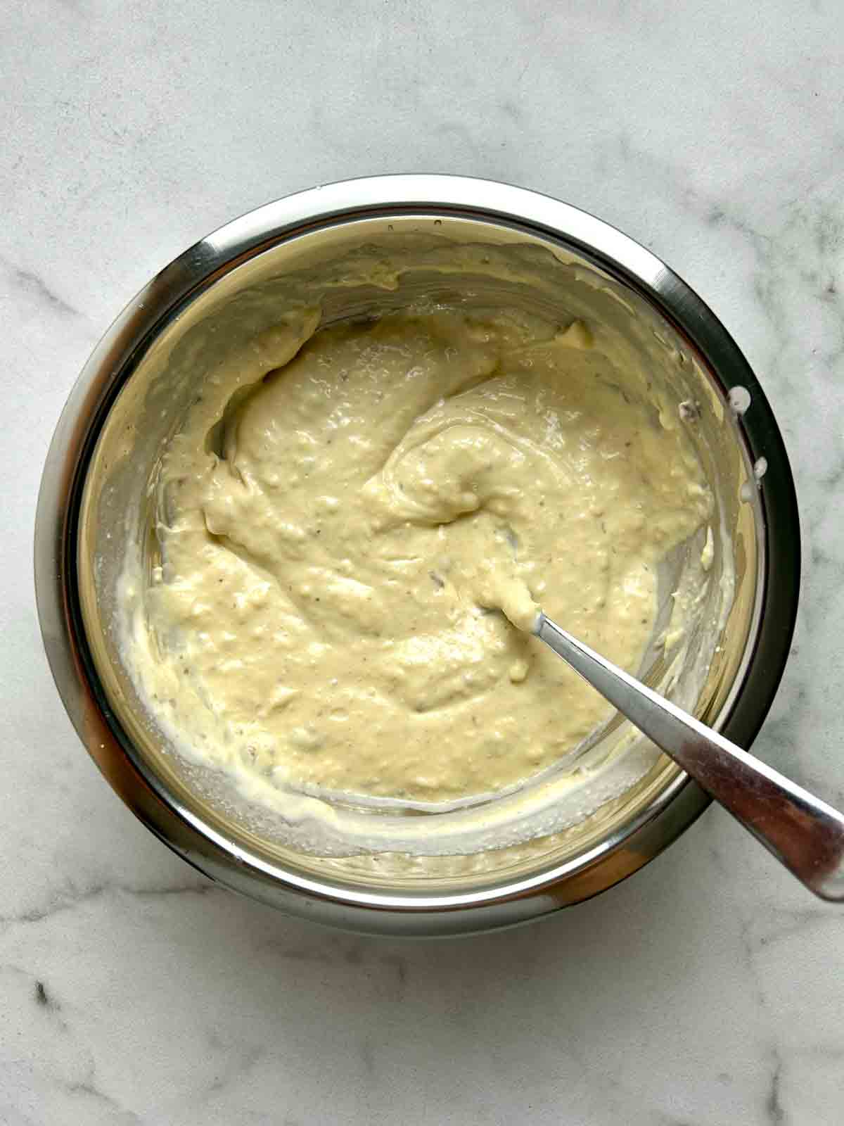 caesar dressing mixed together in bowl.
