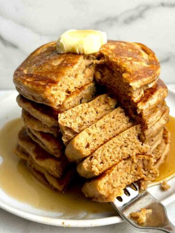 stack of cinnamon brown sugar pancakes with section cut down through middle.