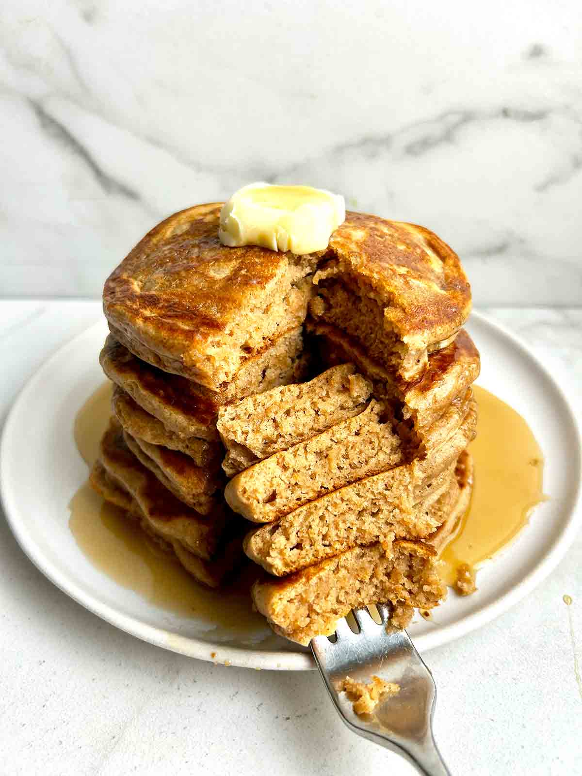 stack of cinnamon brown sugar pancakes with section cut down through middle.