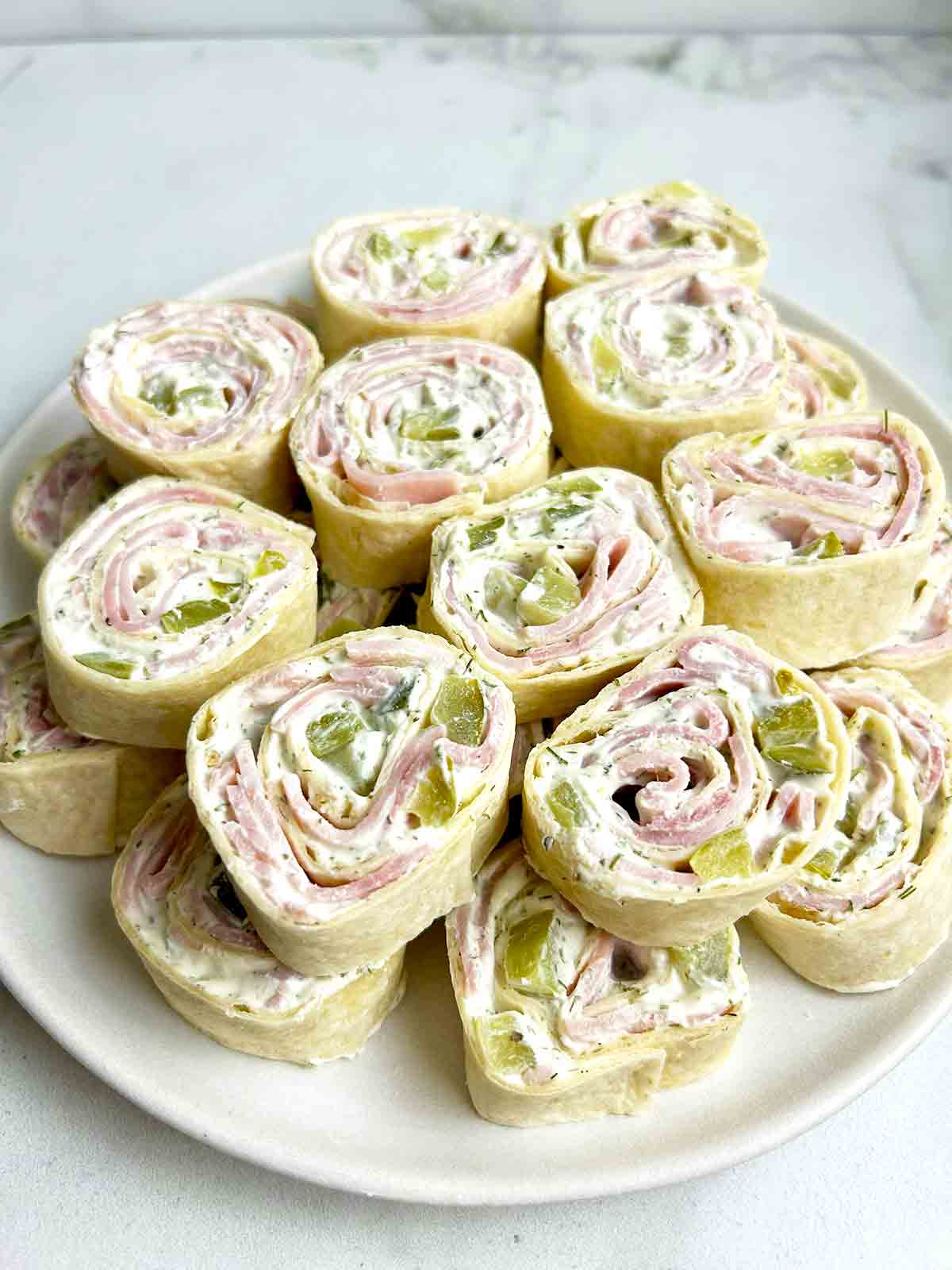 stack of dill pickle pinwheels on plate.