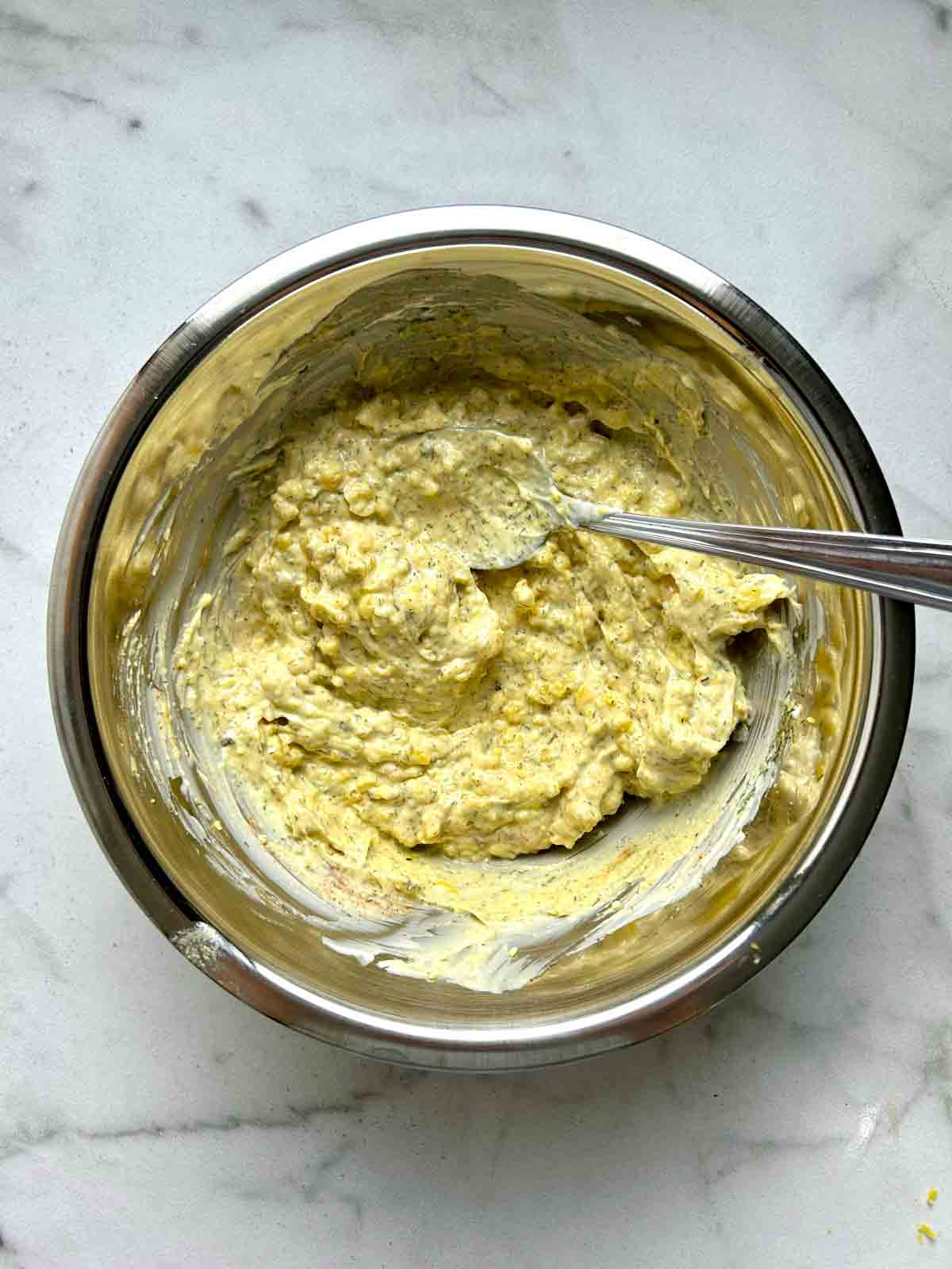 egg yolks mashed with mayonnaise and other seasonings in bowl.