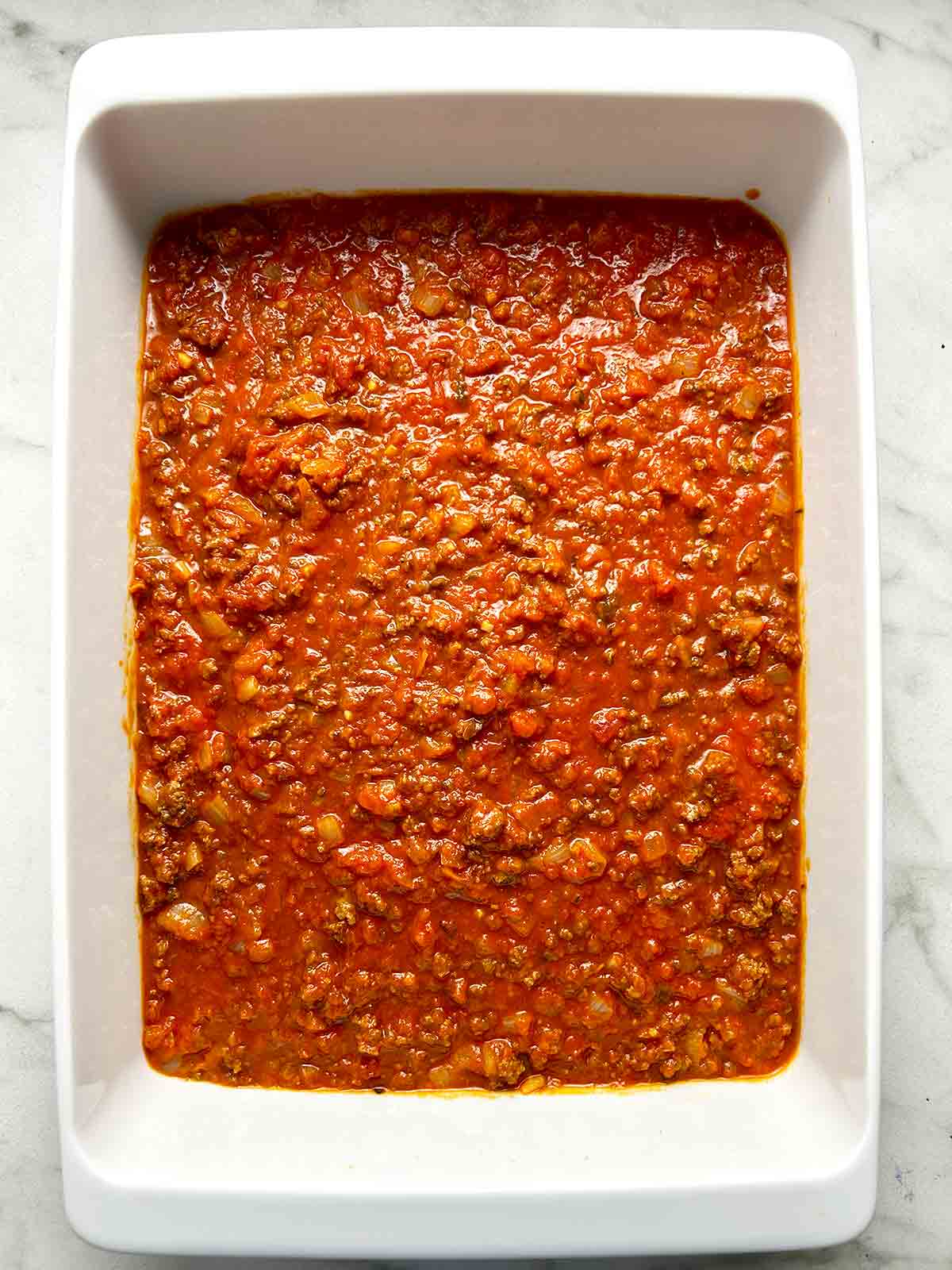 meat sauce spread on casserole dish.