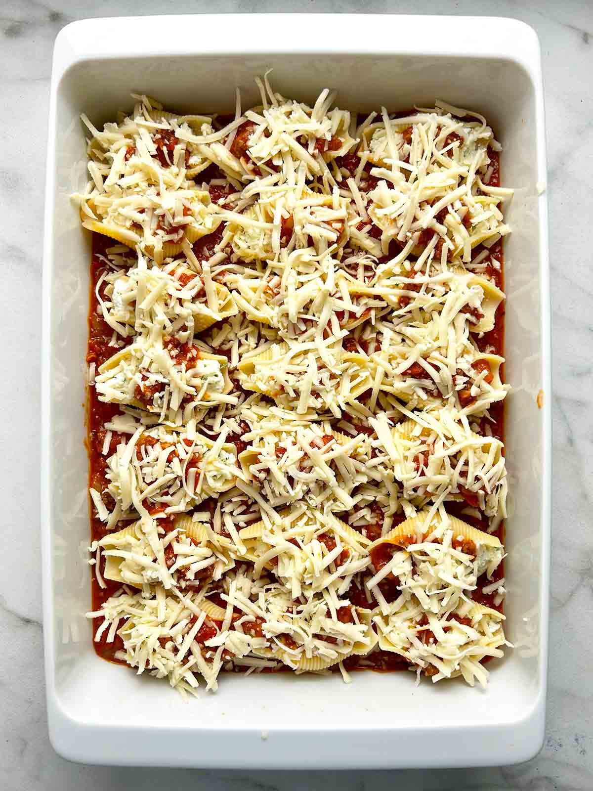 mozzarella cheese sprinkled on top of shells.