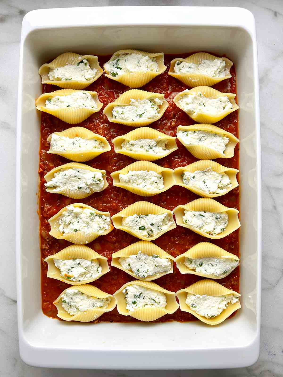 shells stuffed with cheese mixture and arranged in casserole dish.