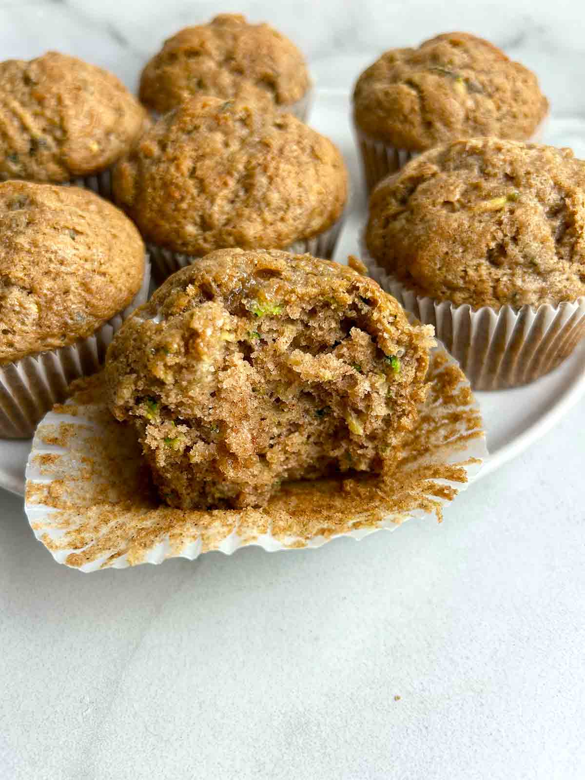 close up of zucchini muffin with bite taken out of it.