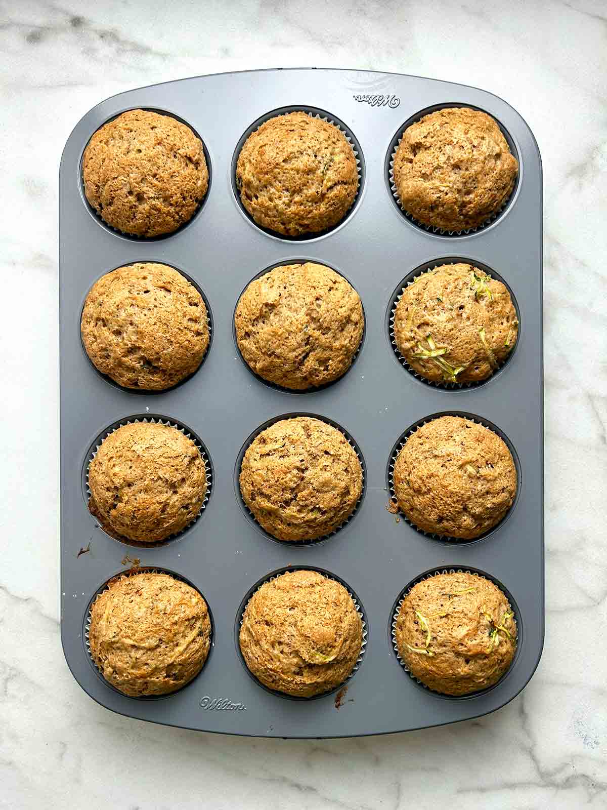 muffins still in pan after baking; golden brown on top.