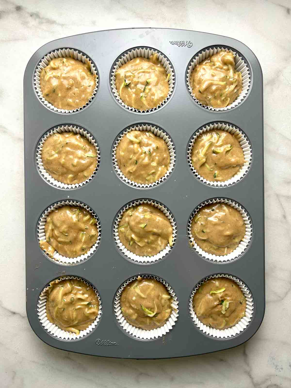 batter spooned into muffin liners in baking pan.