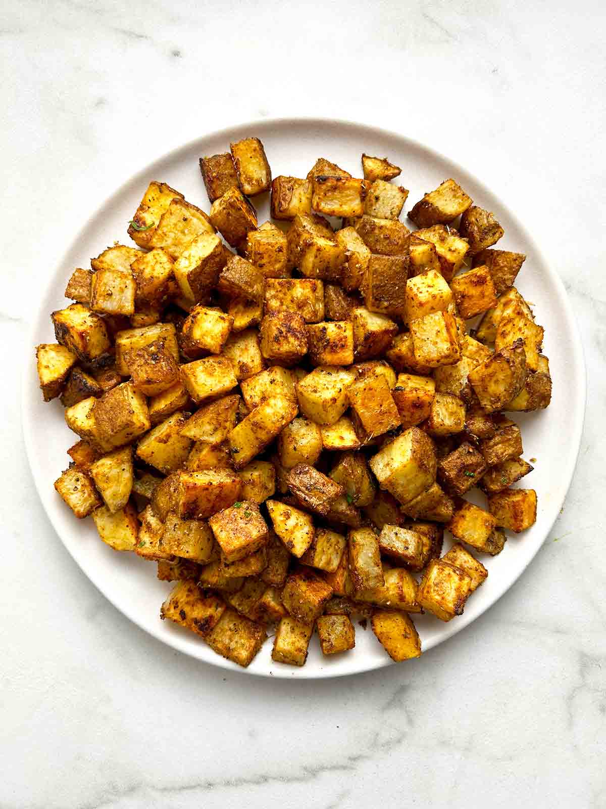 close up of bakes breakfast potatoes on plate.