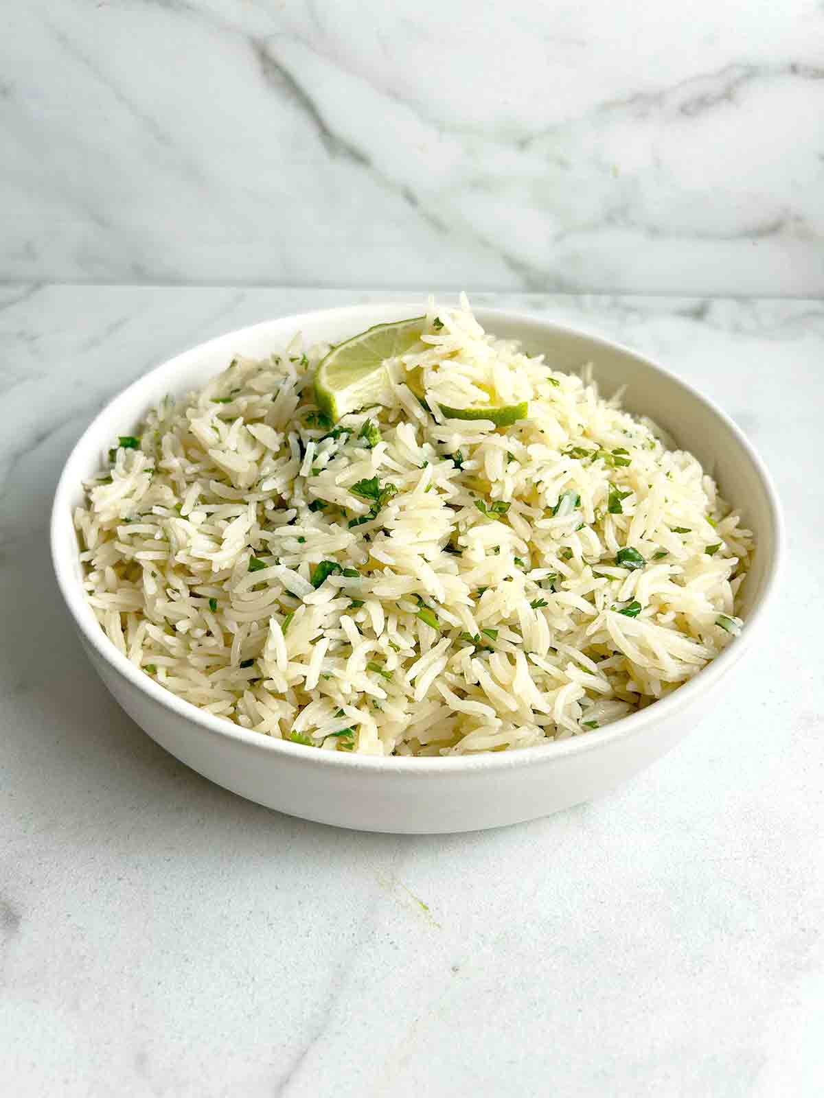 bowl of cilantro lime rice with sliced limes.