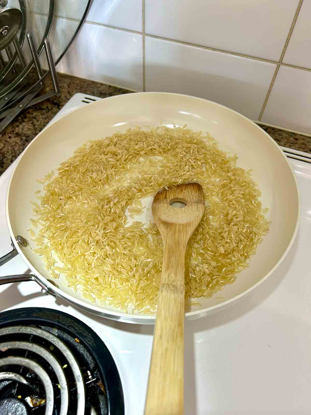 basmati rice being sautéed in large skillet.