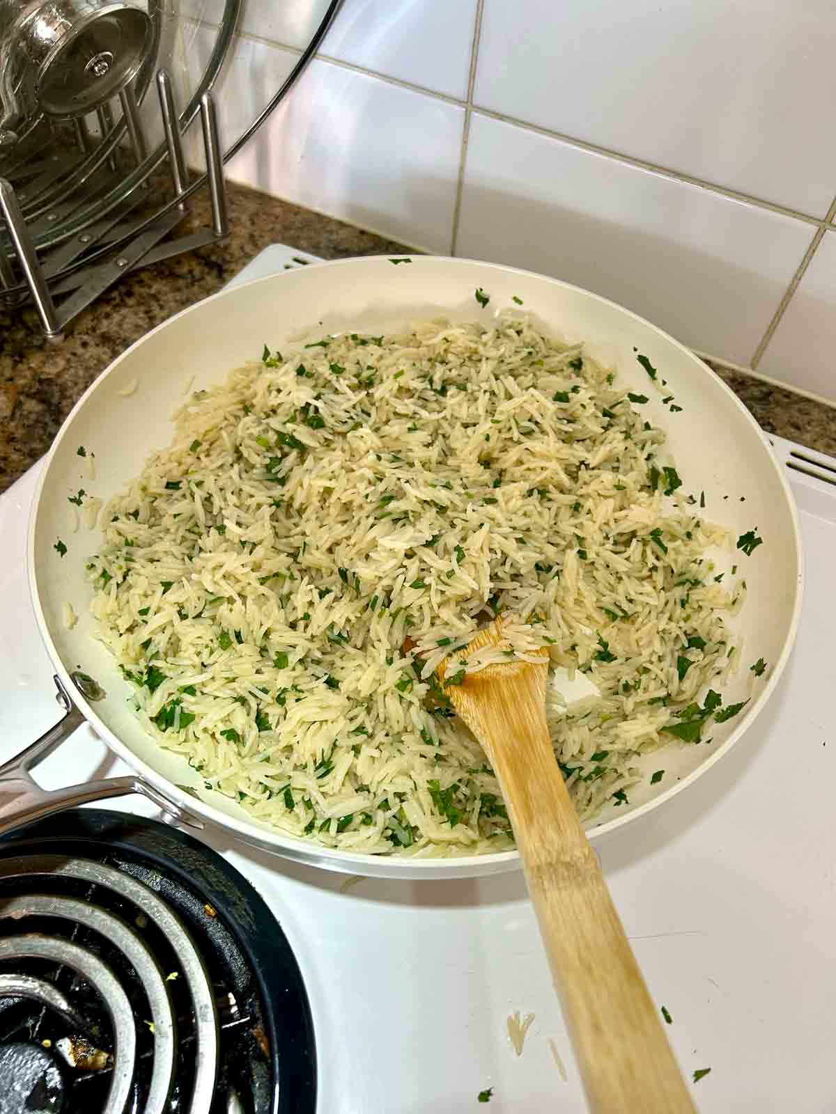 cilantro and lime juice tossed with rice in skillet.
